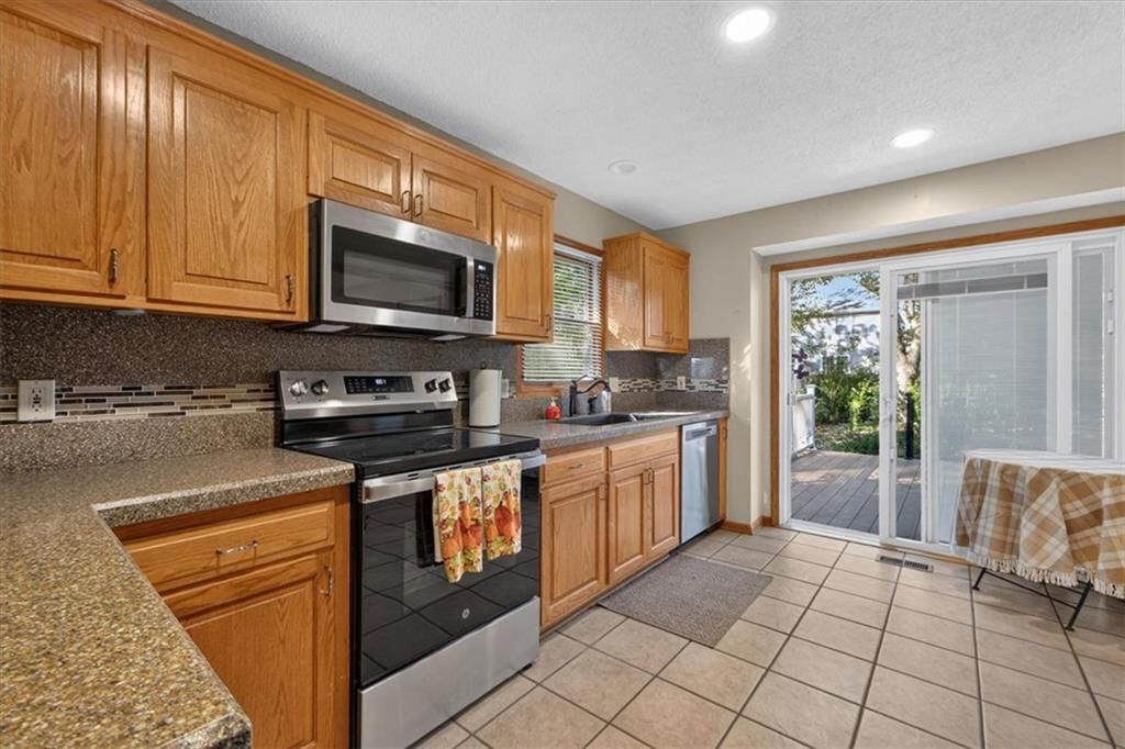 Tile floors, stainless steel appliances and wood kitchen cabinets at 10228 Caenen Drive, Lenexa, KS 66215