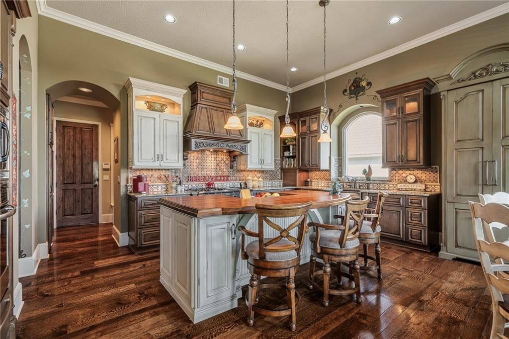 Kitchen island, granite counters and two-tone kitchen cabinets at 8959 Chestnut Street, Lenexa, KS 66220