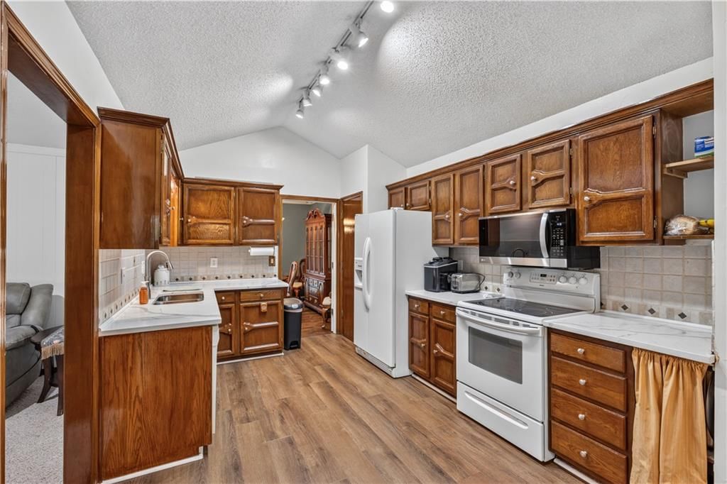 Open floor plan, breakfast nook and wood kitchen cabinets at 5348 W 102 Street, Overland Park, KS 66207