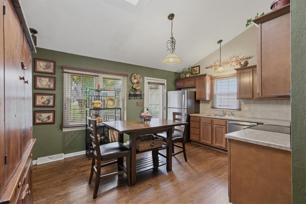 Stainless steel appliances, breakfast nook and wood kitchen cabinets at 3501 Woodbury Street, Independence, MO 64055