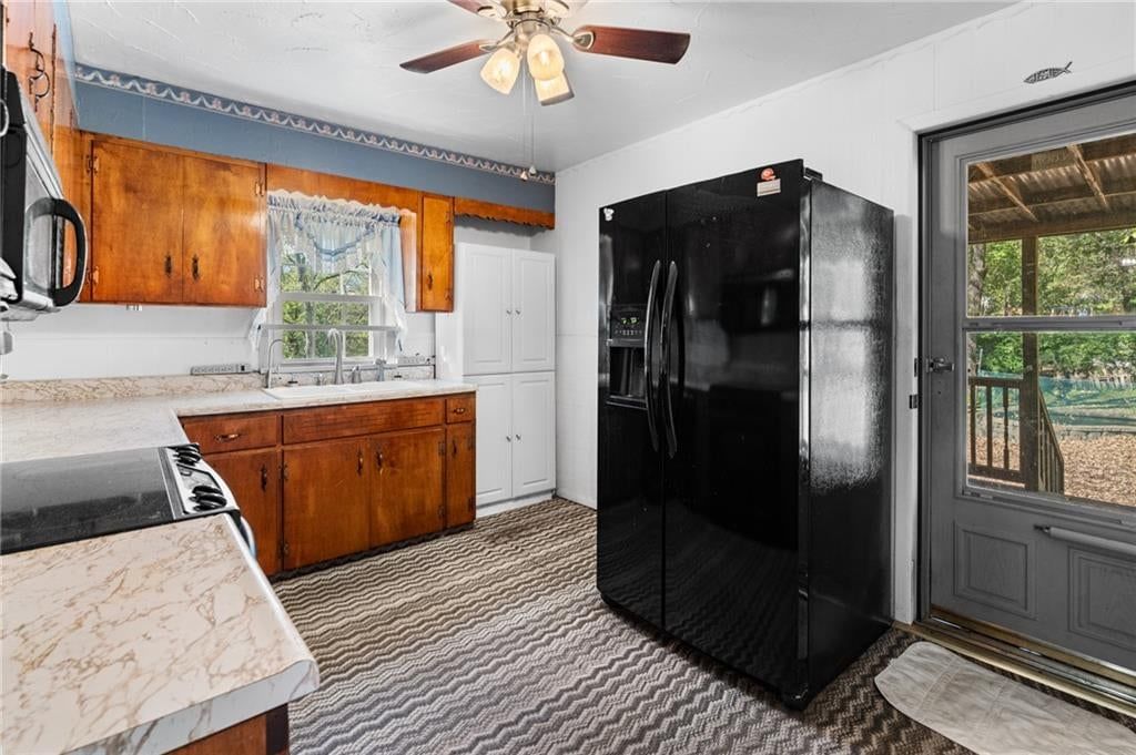 Wood kitchen cabinets and black appliances at 8648 E 27th Street, Kansas City, MO 64129