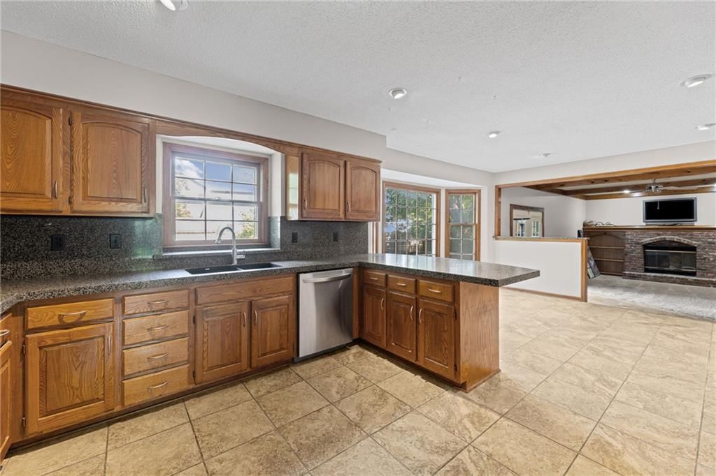 Kitchen island, tile floors and wood kitchen cabinets at 14804 W 84th Terrace, Lenexa, KS 66215