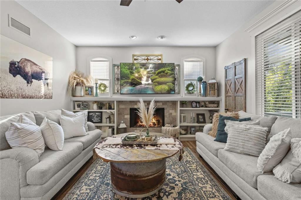 Fireplace, open floor plan and wall of windows at 211 Surrey Court, Smithville, MO 64089