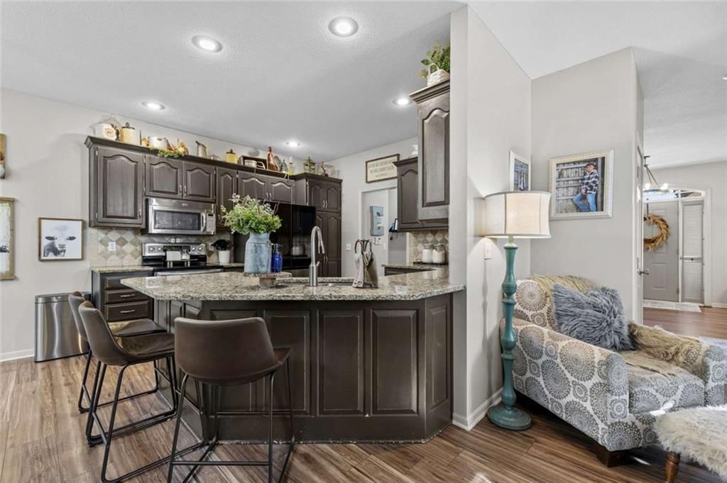 Kitchen island, granite counters and kitchen backsplash at 211 Surrey Court, Smithville, MO 64089