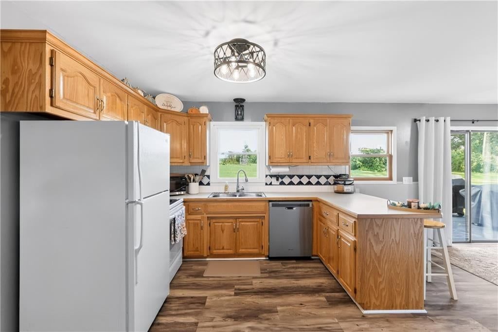 Kitchen island, kitchen backsplash and mixed-finish appliances at 114 W 8th Street, Kearney, MO 64060