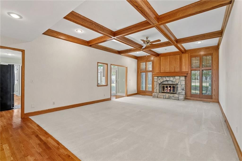 Fireplace, hardwood floors and coffered ceiling at 12808 Sherwood Drive, Leawood, KS 66209