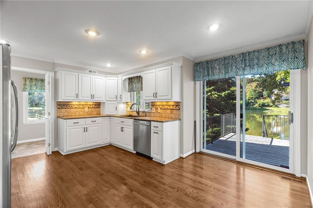 White kitchen, granite counters and stainless steel appliances at 3806 NE Beechwood Drive, Lee's Summit, MO 64064