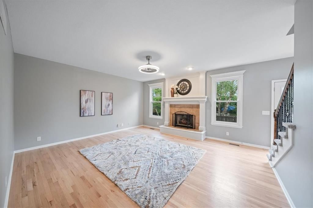 Fireplace, open floor plan and wall of windows at 10138 Theden Circle, Lenexa, KS 66220