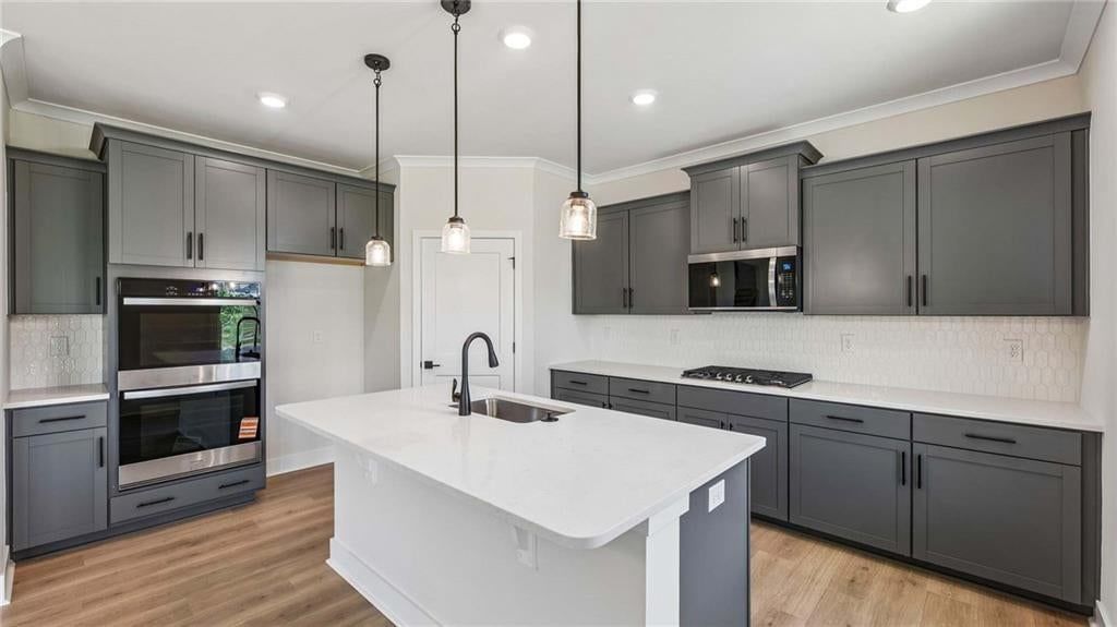 Kitchen island, engineered wood floors and quartz counters at 16798 S Loiret Street, Olathe, KS 66062