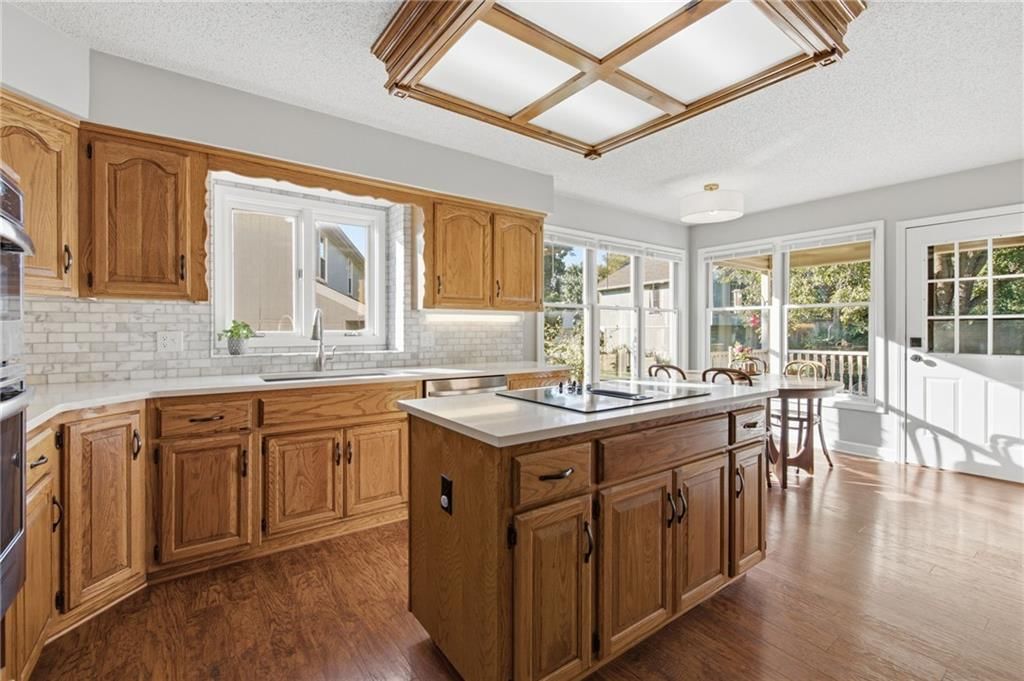 Kitchen island, hardwood floors and kitchen backsplash at 11212 W 115TH Street, Overland Park, KS 66210