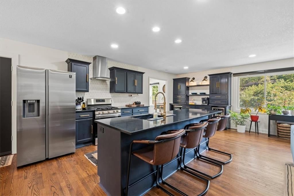Kitchen island, gas range and black kitchen cabinets at 8601 Belleview Avenue, Kansas City, MO 64114