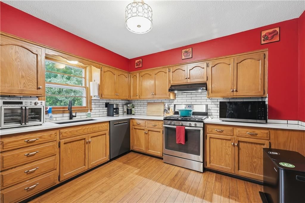 Gas range, wood kitchen cabinets and kitchen backsplash at 8024 NW Cadwallader Road, Kansas City, MO 64152
