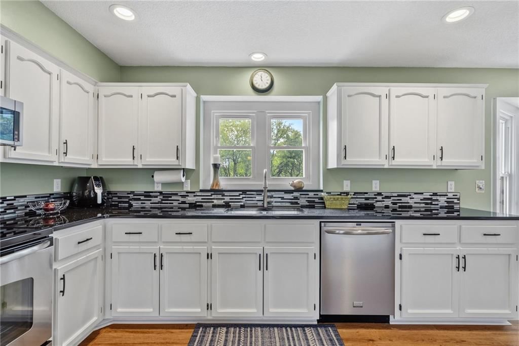 White kitchen, stainless steel appliances and kitchen backsplash at 7001 W. 202nd Terrace, Stilwell, KS 66013