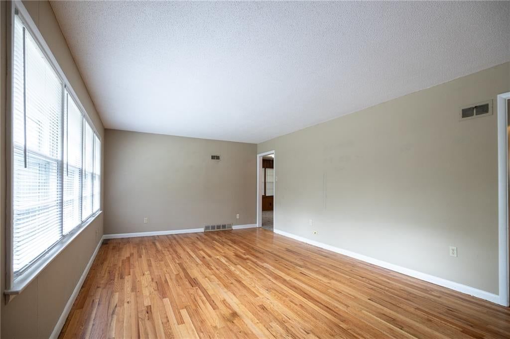 Main-floor primary bedroom and hardwood floors at 5444 N Cypress Avenue, Kansas City, MO 64119