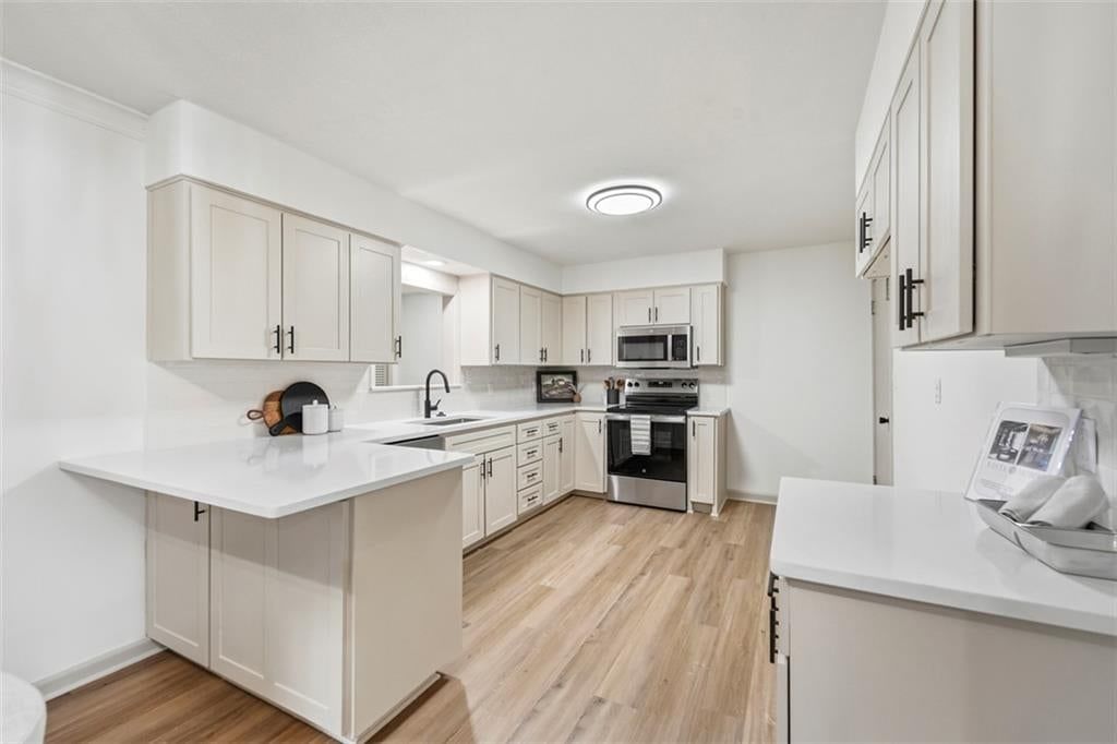 Kitchen island, off-white kitchen cabinets and shaker cabinets at 5416 NE Circle Drive, Kansas City, MO 64119