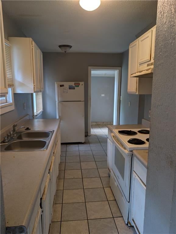 Kitchen open to the living area, white kitchen and tile floors at 3030 Bales Avenue, Kansas City, MO 64128