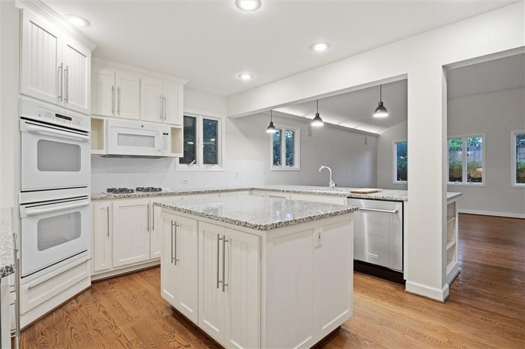 Kitchen island, white kitchen and granite counters at 4124 Brookridge Drive, Fairway, KS 66205