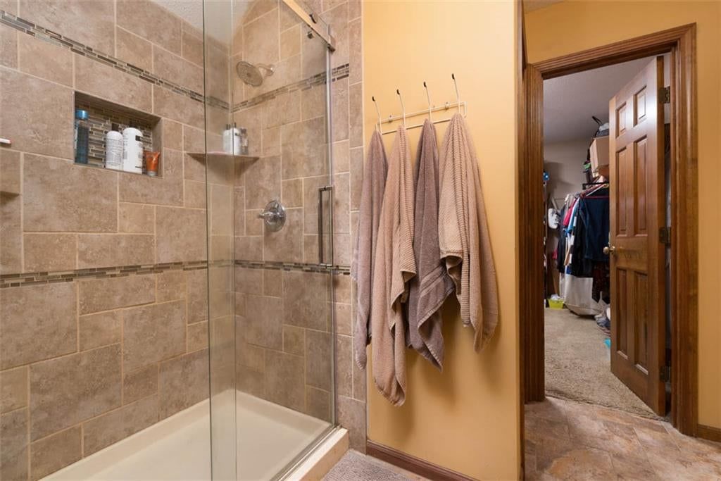 Walk-in shower and tiled shower at 719 White Oak Lane, Gladstone, MO 64116