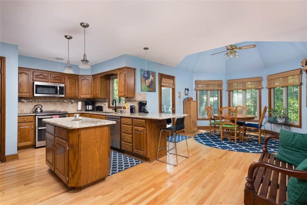 Kitchen island, hardwood floors and granite counters at 719 White Oak Lane, Gladstone, MO 64116