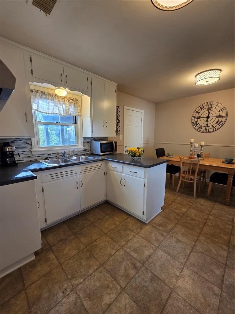 White kitchen, breakfast nook and kitchen backsplash at 10911 W 56th Street, Shawnee, KS 66203