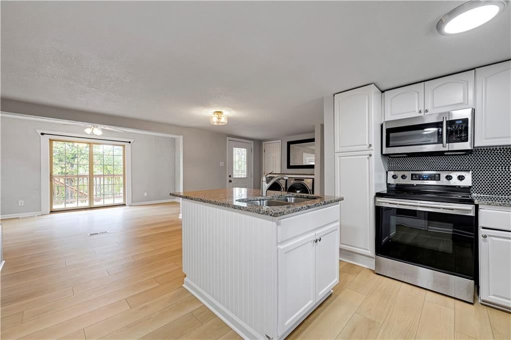 Kitchen island, white kitchen and shaker cabinets at 165 T Street, Lake Lotawana, MO 64086