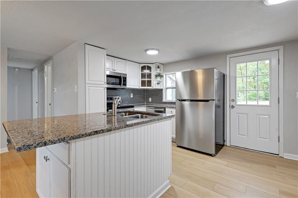 Granite counters, electric range and beige or brown countertops at 165 T Street, Lake Lotawana, MO 64086