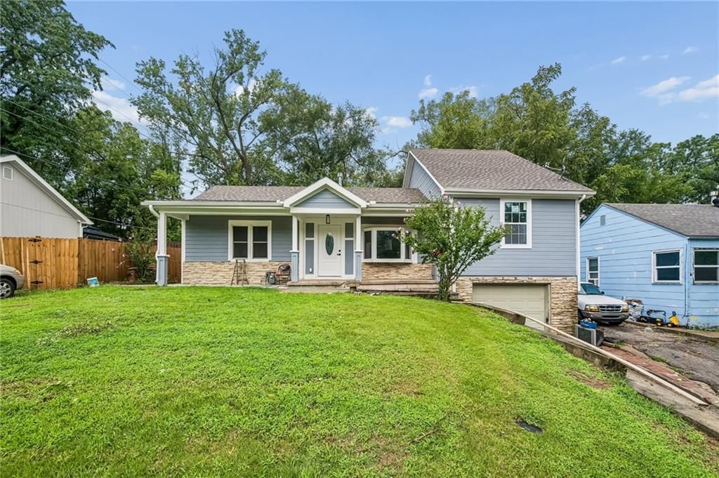Covered front porch, fenced yard and mature trees at 1514 N 51st Street, Kansas City, KS 66102