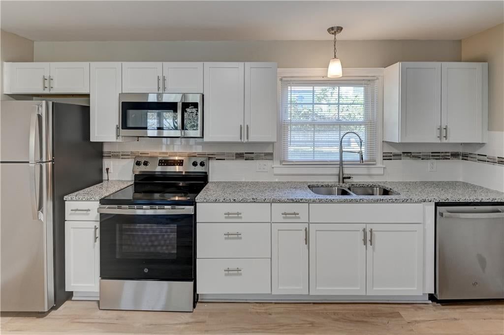 White kitchen, shaker cabinets and stainless steel appliances at 2708 S Glenwood Avenue, Independence, MO 64052