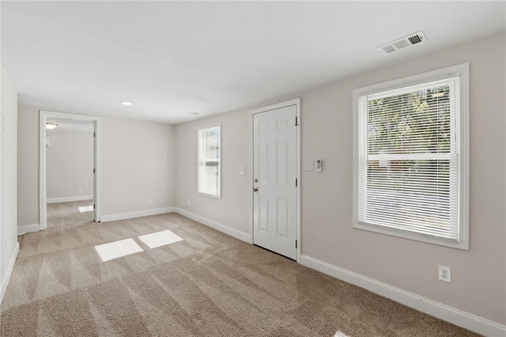 Main-floor primary bedroom, white trim and carpet at 4922 Blue Lane, Kansas City, KS 66104
