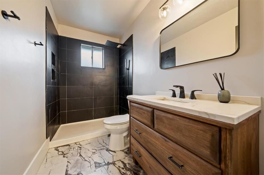 Walk-in shower, tiled shower and renovated bathrooms at 8727 Sycamore Avenue, Kansas City, MO 64138