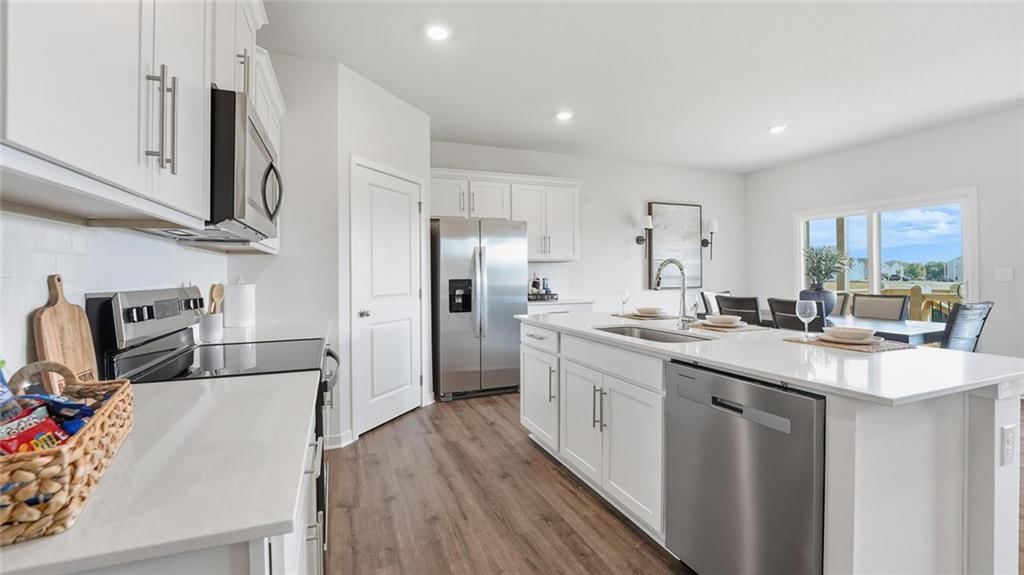 Kitchen island, white kitchen and walk-in pantry at 626 Solstice Circle, Belton, MO 64012