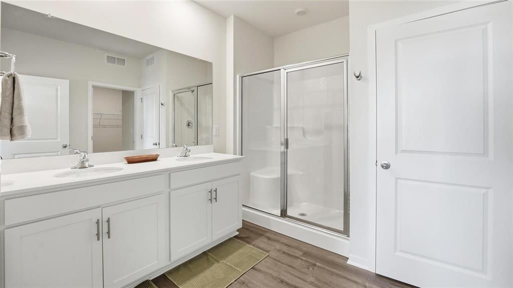 Walk-in shower, double vanity and white vanity at 626 Solstice Circle, Belton, MO 64012