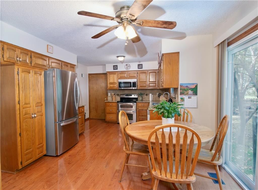 Kitchen open to the living area, hardwood floors and granite counters at 15800 W 125th Terrace, Olathe, KS 66062