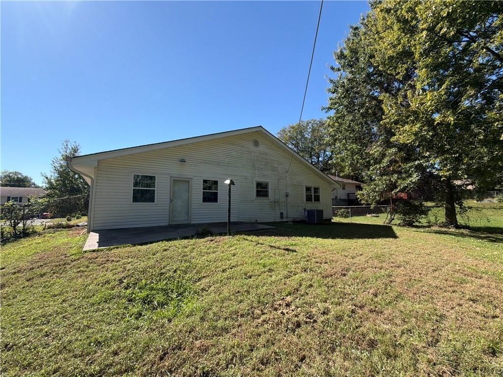 Fenced yard, mature trees and chain-link fence at 602 W 101st Street, Kansas City, MO 64114