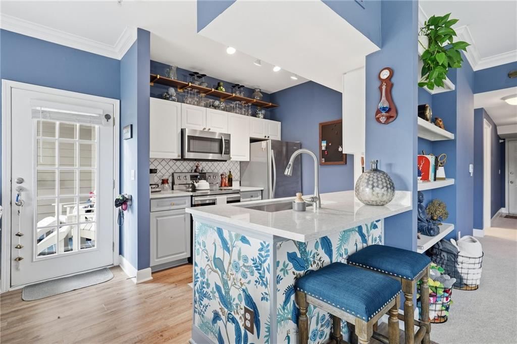 Kitchen island, white kitchen and kitchen backsplash at 11604 Tomahawk Creek Parkway #A, Leawood, KS 66211
