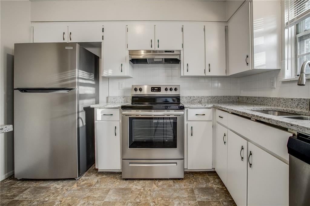White kitchen, stainless steel appliances and electric range at 607 NE Lynn Street, Lee's Summit, MO 64063