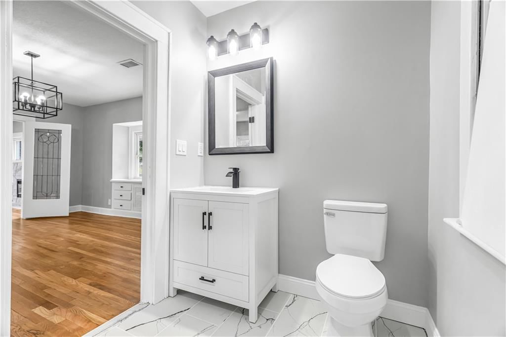 Tiled shower, white vanity and renovated bathrooms at 710 N 17th Street, Kansas City, KS 66102