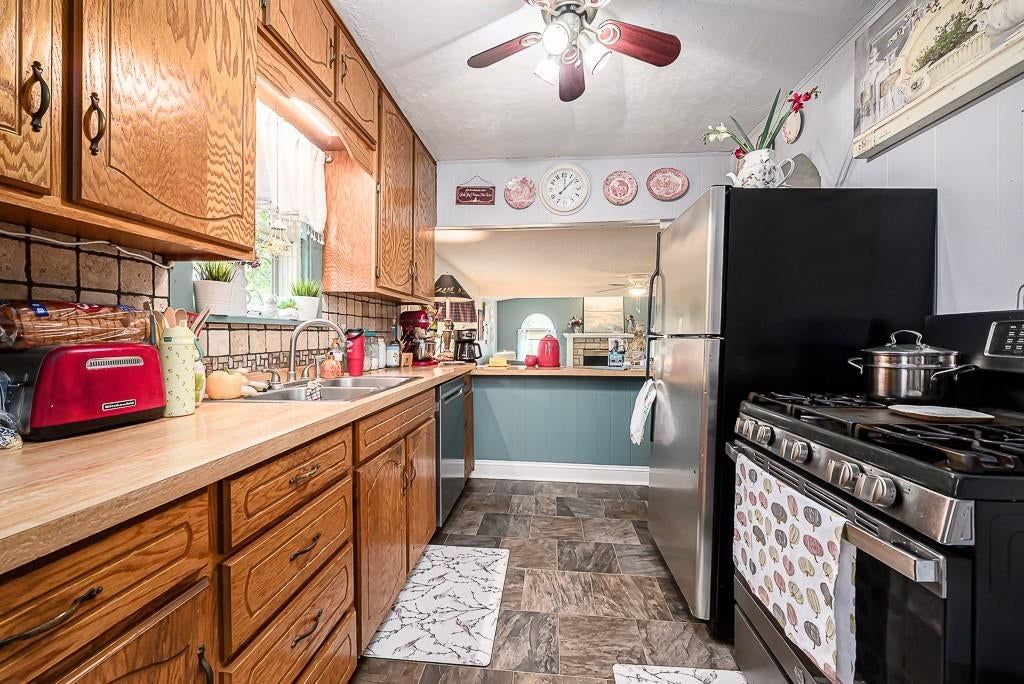 Gas range, wood kitchen cabinets and kitchen backsplash at 15552 Ripley Street, Basehor, KS 66007
