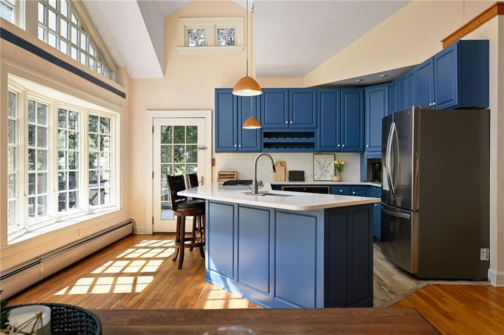 Kitchen island, statement lighting and blue kitchen cabinets at 7444 Mercier Street, Kansas City, MO 64114
