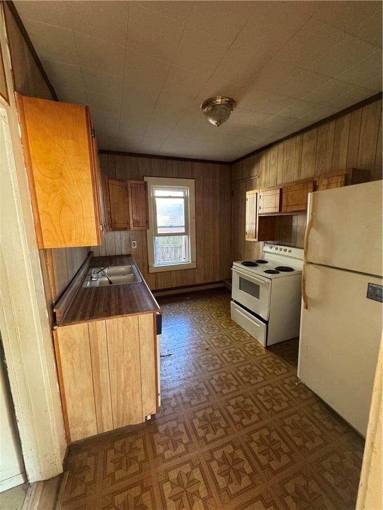 Wood kitchen cabinets, white appliances and electric range at 316 S White Avenue, Kansas City, MO 64123
