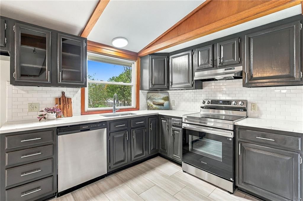 Stainless steel appliances, electric range and kitchen backsplash at 5901 N Michigan Place, Gladstone, MO 64118