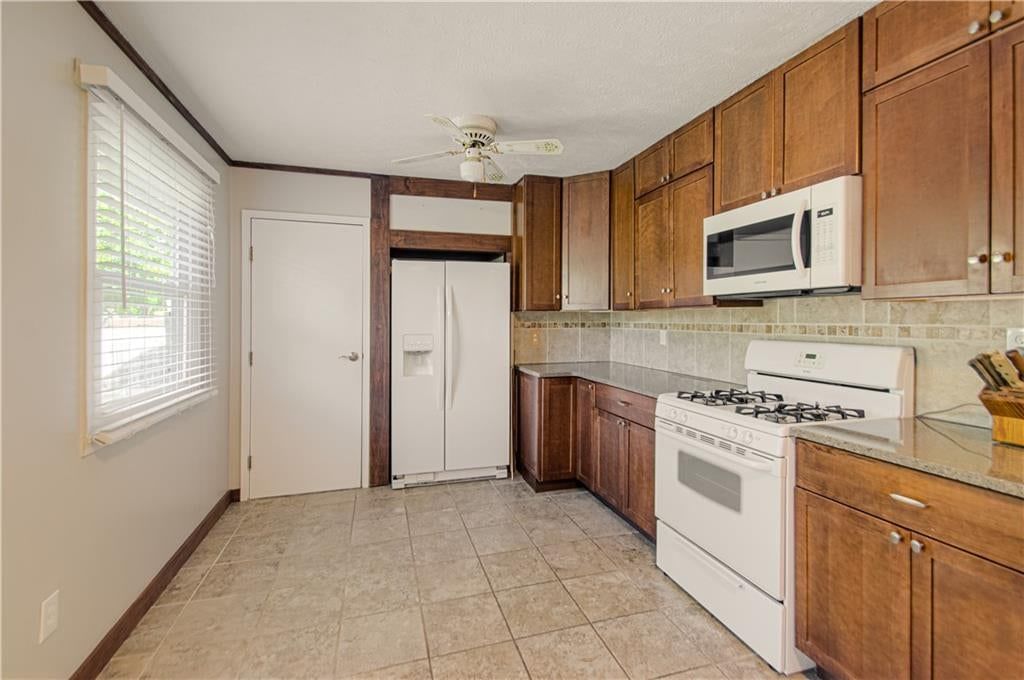 Gas range, tile floors and wood kitchen cabinets at 10006 Benson Street, Overland Park, KS 66212