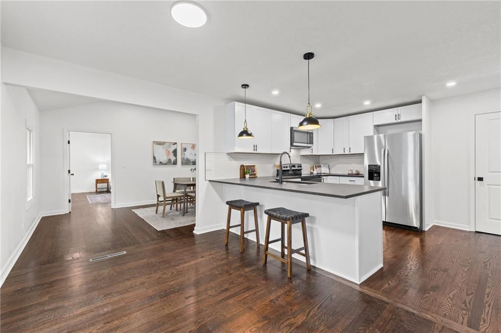 Kitchen island, white kitchen and statement lighting at 8108 E 92nd Terrace, Kansas City, MO 64138