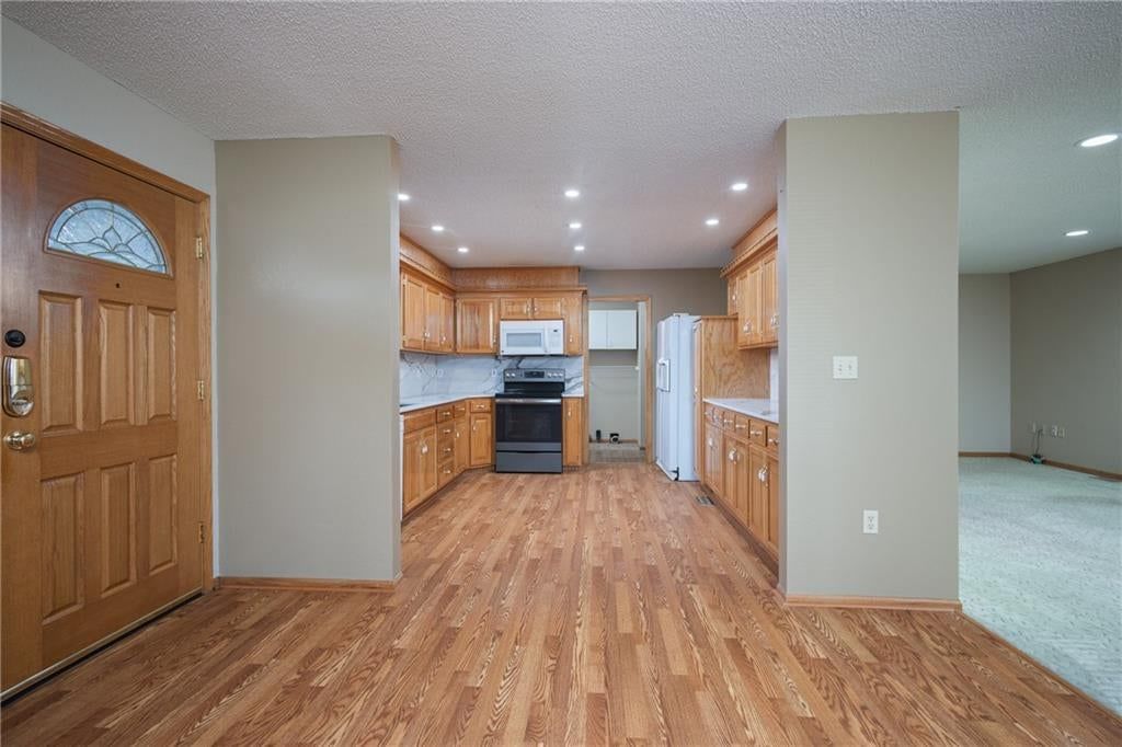 Wood kitchen cabinets, raised-panel cabinets and recessed lighting at 116 Sibley Street, Buckner, MO 64016