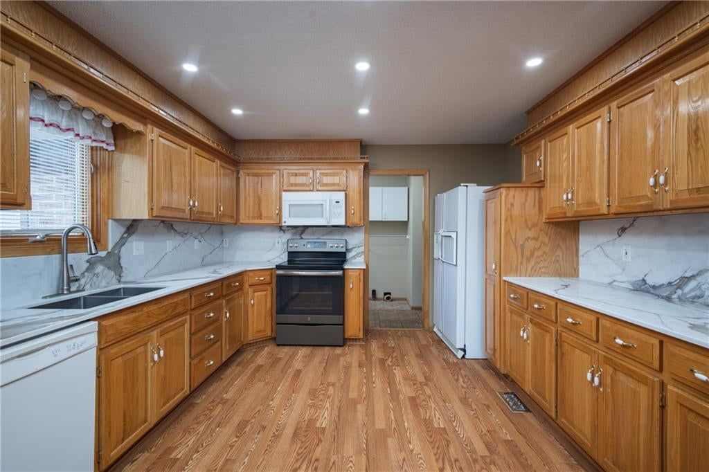 Electric range, kitchen backsplash and slab backsplash at 116 Sibley Street, Buckner, MO 64016