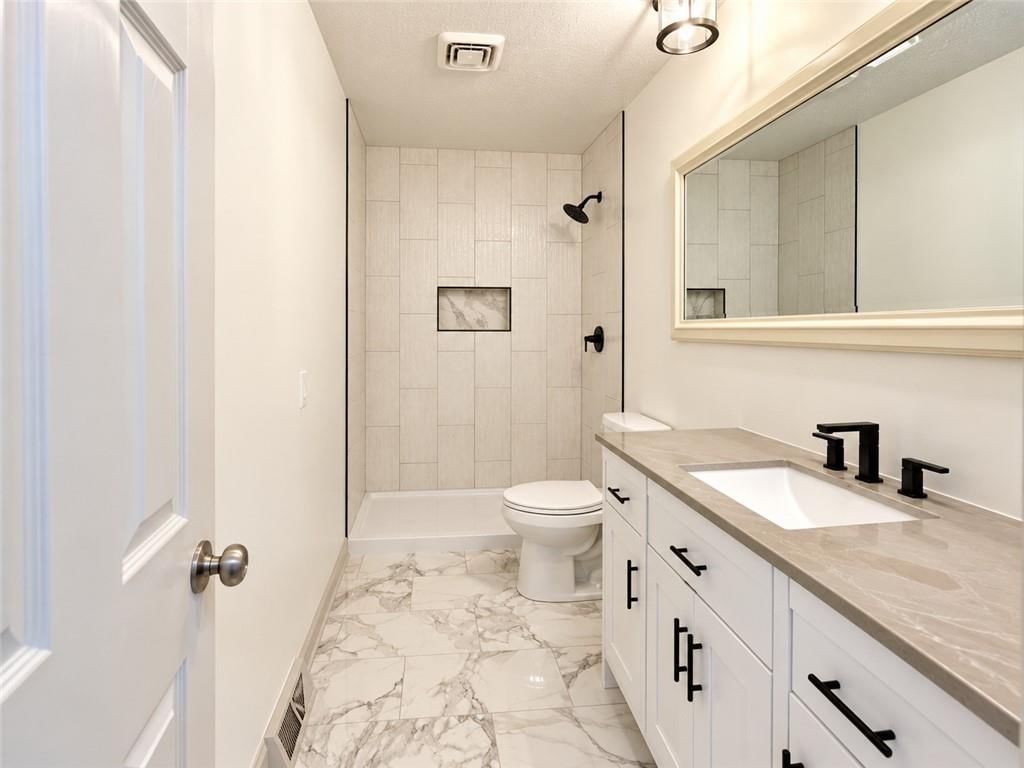Walk-in shower, tiled shower and double vanity at 816 NW Oxford Drive, Independence, MO 64015