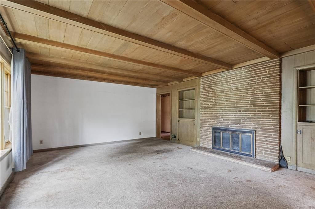 Fireplace, exposed brick wall and ceiling beams at 8932 E 66th Street, Raytown, MO 64133