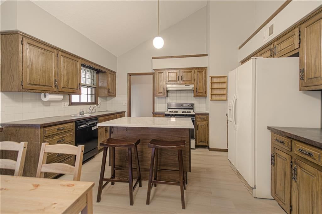 Kitchen island, breakfast nook and kitchen backsplash at 9835 W 101st Street, Overland Park, KS 66212