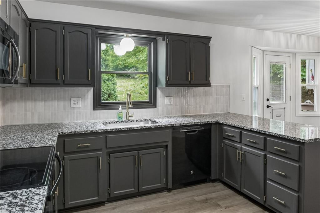 Granite counters, electric range and kitchen backsplash at 7606 NW 73rd Court, Kansas City, MO 64152