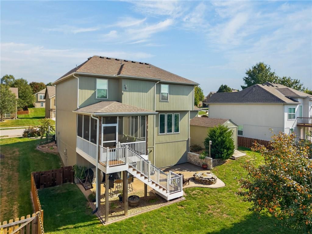 Big backyard, fire pit and screened porch at 406 Buck Court, Kearney, MO 64060